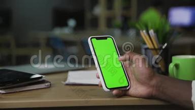 背部特写观看的非洲男子<strong>上网</strong>使用手机与<strong>绿色</strong>屏幕。